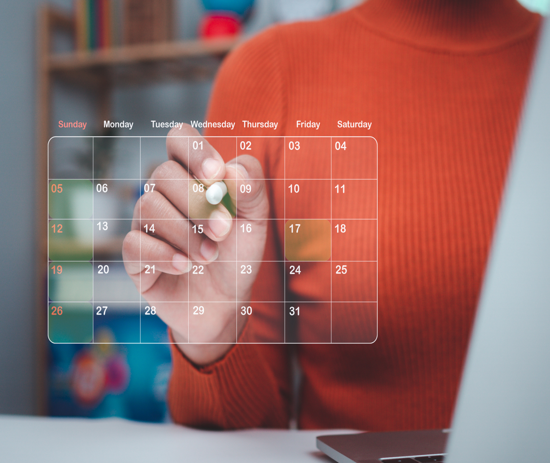 Person marking dates on a transparent calendar.