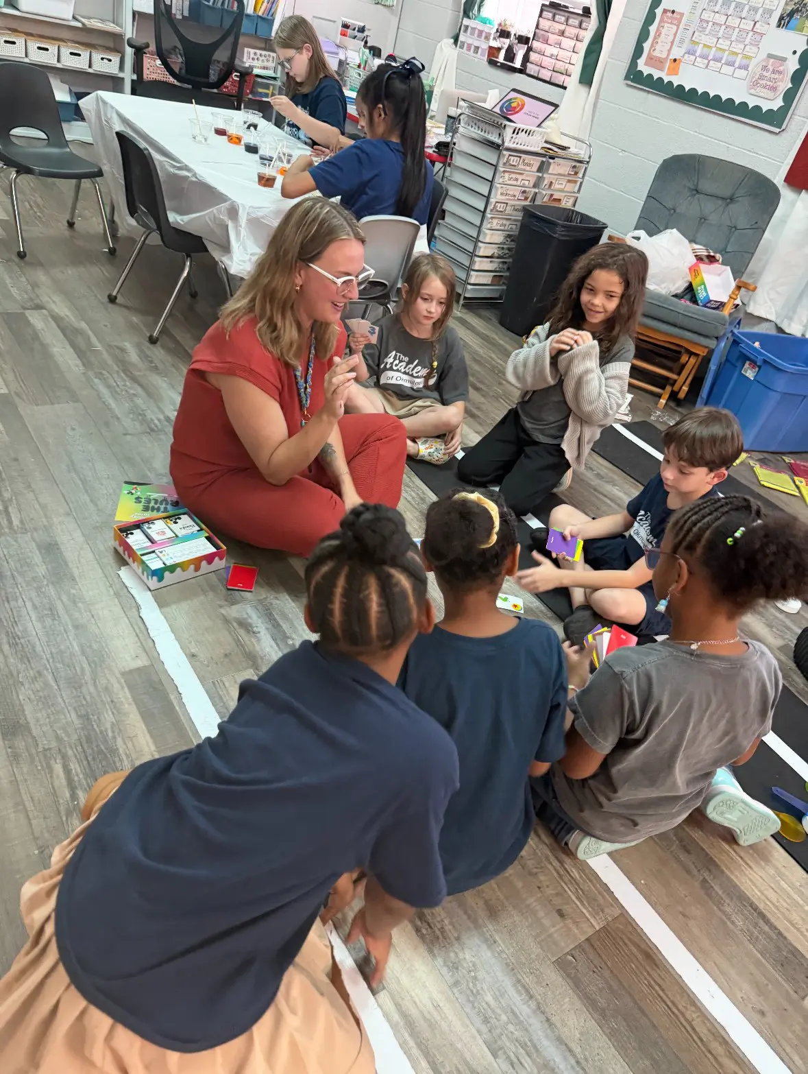 A group of children and adults engaged in a hands-on activity indoors.
